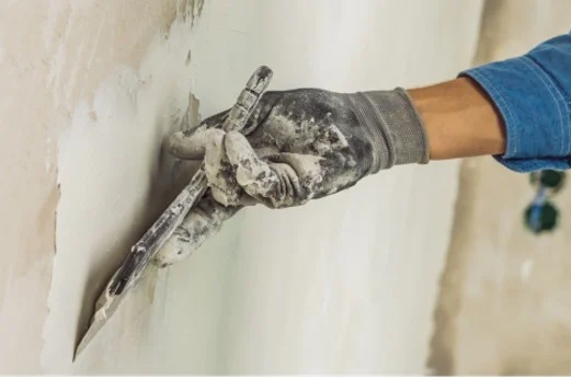 Person verspachtelt Wand